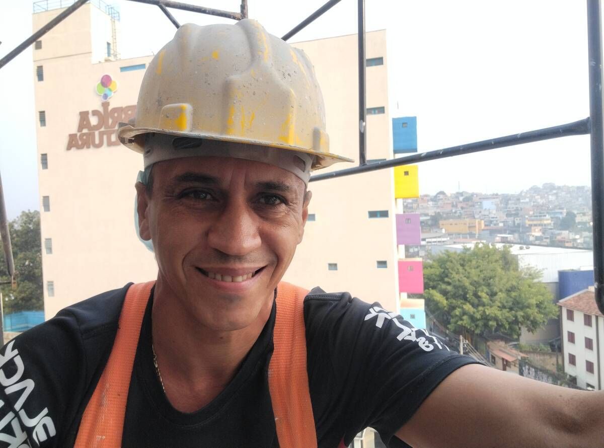 Maerosilva pintando fachada de prédio.